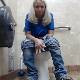 A mature, older blonde woman takes a gassy, runny shit while sitting on a public restroom toilet at a gas station. Someone knocks on the bathroom door while she continues to push more out. Presented in 720P HD. Over 2 minutes.